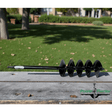 Black 5" auger on weathered wooden board, with a blurred green lawn and trees in the background. 